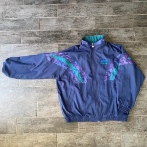 Vintage Umbro jacka - En vintage Umbro jacka i storlek 42 men sitter som M/L skulle jag säga. Den är i hyfsat skick med tanke på sin ålder bara nått hål och lite fläckar som syns på bilderna.