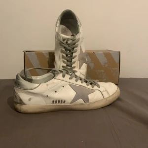 Golden goose -  Säljer mina goldengoose skick 5/10 som man ser på bilderna. Har ett hål på höger sida av vänstra skon men inget som en skomakare inte kan fixa för max 300kr. Storlek 42 men jag som har 43 kan använda. Tar emot byten. Box medföljer.