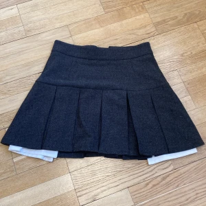 Skirt with white fabric peeking out  - The skirt is from ukrainian brand “Cher17” The skirt looks like these miu miu skirts Can be styled in winter cuz 40% of the material is wool 