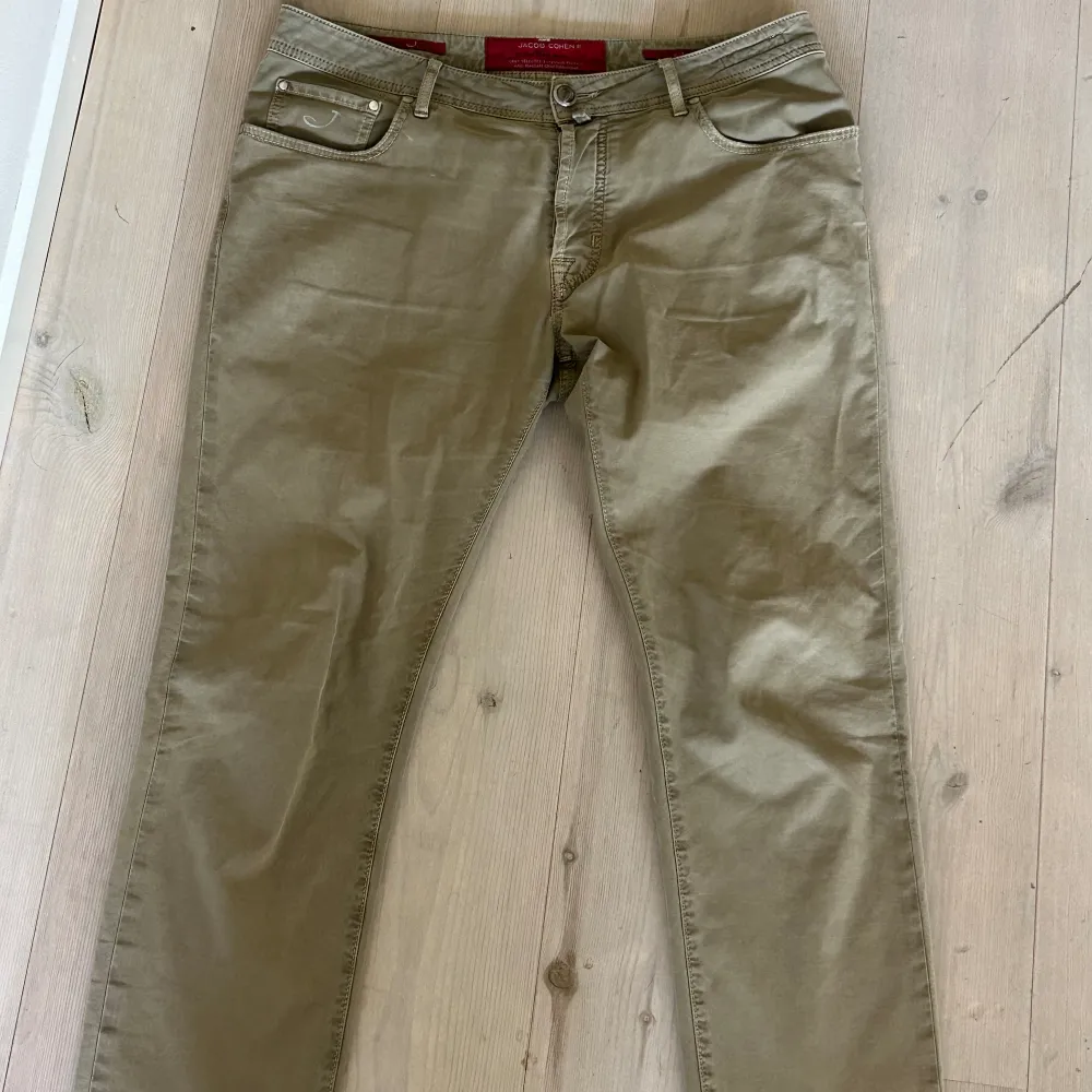 Chinos/jeans från Jacob Cohen. Det är ett hål ”under” den vänstra bakfickan. Den översta knappen på gylfen sitter även den löst, därav priset. . Jeans & Byxor.