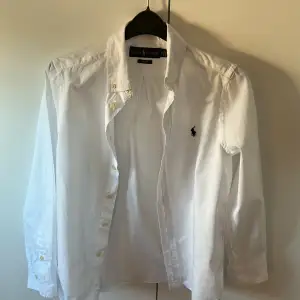 En klassisk vit polo skjorta i storlek 14 slimfit som motsvarar xs. Skick 9/10 använd ett par gånger. Inga fläckar eller märken. 