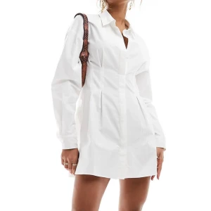 Vit mini-skjortklänning - Säljer denna fina skjortklänning med indragen midja. Klänningen är köpt från asos, aldrig använd & prislappen kvar. (Slutsåld i alla storlekar på hemsidan). Säljer pga för sent för retur.🌷 Nypris: 509kr