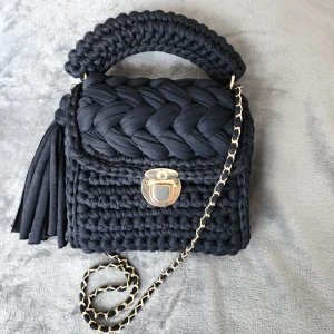 Handvirkad väska  - Handvirkad väska av zpagetti garn i svart färg (har gjort den själv). Är rymlig samt tjusig. Passar till det mesta. Om du vill ha i en annan färg eller storlek, tveka inte att skicka ett meddelande. Produkten är i djur och rökfritt miljö.