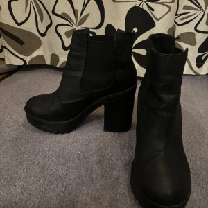 Hög boots - Ett par använda hög klackade boots från divided, jättesnygga på.