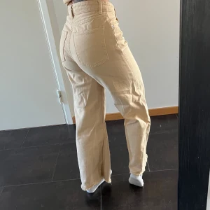 Ljusa jeans - Ett par beiga jeans från monki. Bekväma och modellen är med breda ben men formar ändå bakdelen fint😊