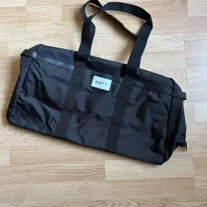 Helt ny weekendväska från day et, aldrig använd, köpt 2024. Säljer då jag redan har en liknande. Köpt för 1099kr.  Bredd: 55.5 cm Höjd: 31 cm Längd på rem: 70 cm