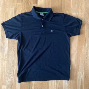 Lacoste Piké - Svart Kashmir Lacoste Piké | Storlek L men passar S och M vuxen. 100% äkta, bara gammal så det är därför neck taggen ser ut som den gör. 