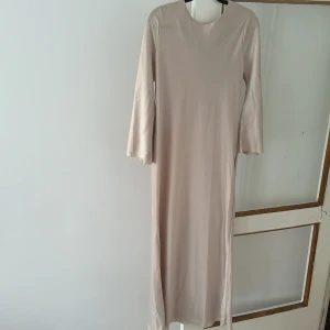 Satin maxiklänning - En oanvänd lång elegant ljusbeige satinklänning i strl M/L. Jag säljer denna eftersom jag vill helst ha en mörkare nyans av beige. 