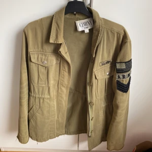 Grön army jacka - Jag säljer denna supersnygga army jackan. Jättefin med detalj på ärmen (se bild 3) 