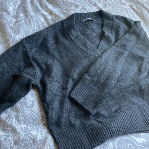 Super fin oversized stickad tröja!!💗 - Säljer denna fina tröja då den inte kommer till användning.🙏🏼 Den är  väldigt mörk grå (nästan svart) och har en v-ringning på framsidan. Fint skick, använd ca 5 ggr. Ord pris 300kr. Priset går att diskuteras vid snabbt köp!❤️