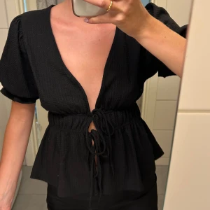 Knytblus - Fin blus/topp med knyte och puffärmar.  I fint skick använd fåtal gånger.  