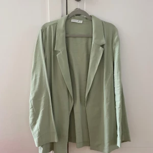 Ljusgrön kavaj från Primark - En ljusgrön/mint kavaj från Primark. Kavajen har en enkel och stilren look med en öppen framsida utan knappar eller dragkedja. Lightweight/tunn och superbekväm! Endast använd en gång. 