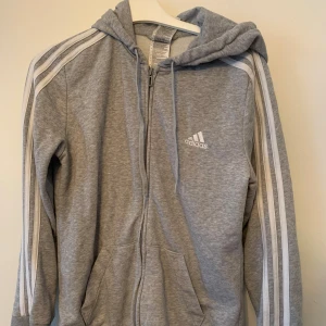 Adidas hoodie - Grå Adidas hoodie. Storlek M. Använd men bra skick - inga skador, inget slitage. Kan mötas upp i Stockholm och Uppsala. 