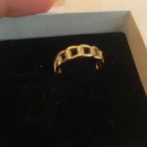 En elegant guldfärgad ring med en unik kedjedesign. 