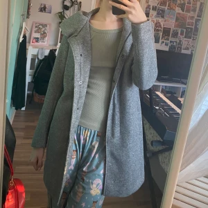 Grå kappa från ONLY - Mycket bra skick! Har knappar och dragkedja och hood :)