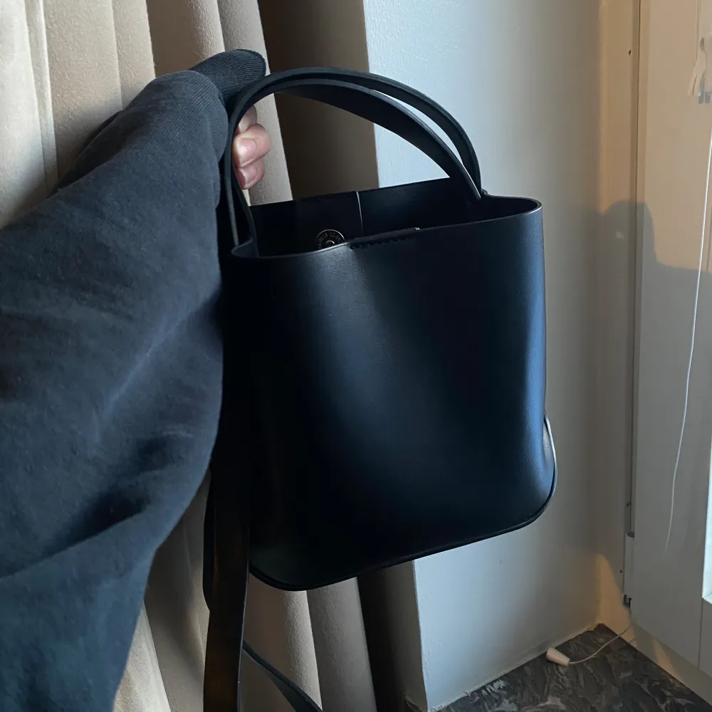 Liten handväska i fyrkantig modell från GinaTricot, har ett litet fack med dragkedja inuti. ca 20-25cm hög.  Otroligt fint skick! Endast använd några få gånger.  Ord. pris 299kr. Väskor.