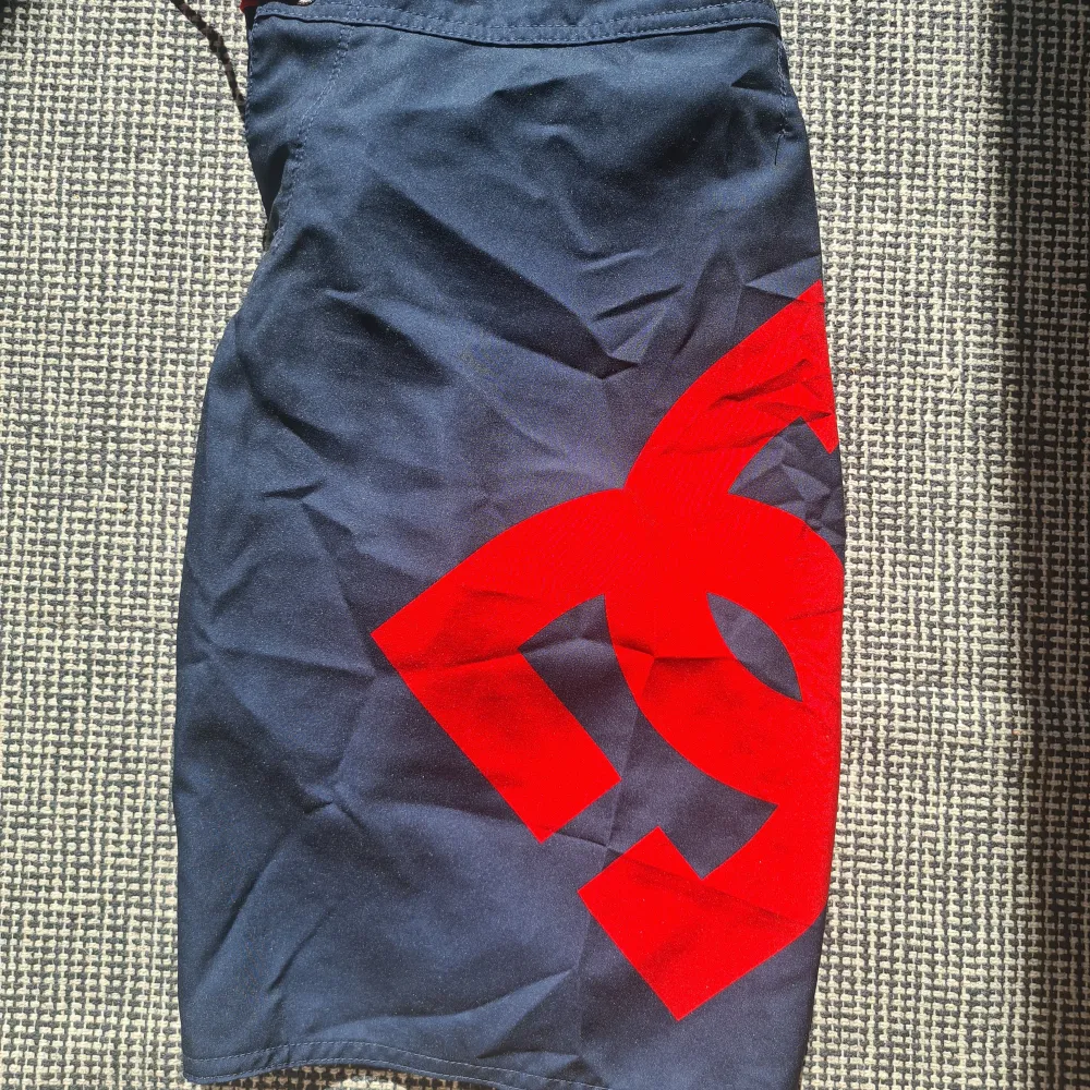 Mörkblå badshorts/boardshorts från DC Shoes Lanai 22 Strl 14 (S)  Oanvända, men prislapp borttagen. Inget att anmärka på, hela och rena och inga missfärgningar.  Rök och djurfritt hem.. Shorts.