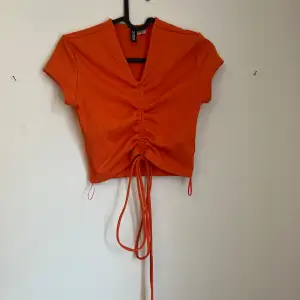 Orange scrunch tie top with a cropped fit 