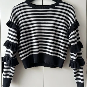 Volang tröja - Säljer nu min stickade tröja med volanger på ärmarna, köpt på Zalando för några år sen. Står ingen storlek i men skulle säga att den är som en xs. Den är även croppad🩷