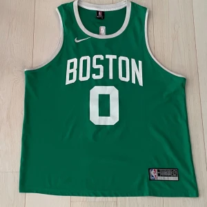 NBA Jersey - Boston Celtics  - Basketlinne/Jersey.  NBA-laget Boston Celtics med Jayson Taytum #0 på ryggen. I gott skick men dessvärre inte äkta, därav det låga priset. Angiven storlek är XXL men sitter som L/XL. 