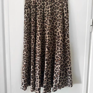 Kjol - Långkjol som går över knäna från H&M Trend i storlek 34. Plisserad och leopardmönstrad. 
