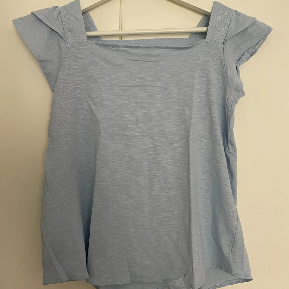 Säljer denna t-shirten/ blusen från zara-kids som är i en ljusblå färg med fina detaljer. Helt ny, bara tvättad. Passar perfekt till sommarn🩵. T-shirts.