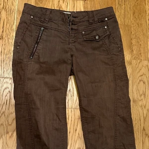 Bruna vintage jeans  - Bruna lågmidjade jeans med bakfickor.