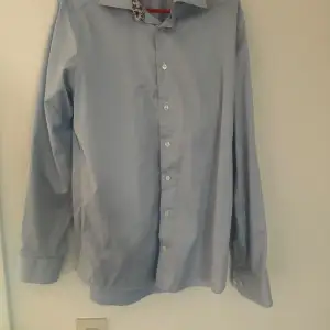Fin ljusblå skjorta som använts fåtal gånger.