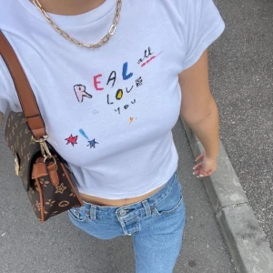 Baby tee - Superfin baby tee från bikbok som påminner om den mycket populära t-shirten från märket realisation par. Den är endast använd någon gång & i nyskick, men behöver strykas! Storlek M, men skulle säga att den passar någon med S också🤍