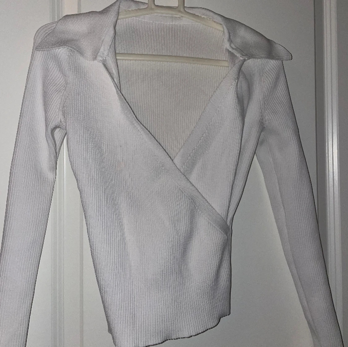 Vit tröja med korsning fram 