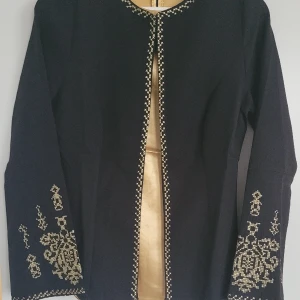 Svart Kavaj med satinblus - Säljer an jättesnygg kavaj med satinaktig blus. Kavajen har tjusiga spetsdetaljer. 90% bomull. Settet har en lång svart kjol. Storlek 38 morsavar M. Skriv i privat för mer info