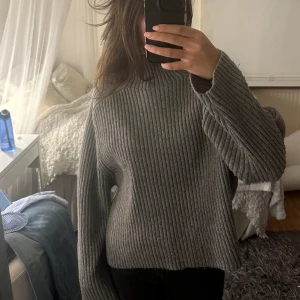 H&M grå stickad tröja - Grå stickad tröja från H&M. Lite nopprig nedtill.