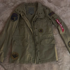 militär jacka - jacka ifårn alpha industries, köpt för väldigt länge sen. aldrig använd. går att dra in i midjan så man får mer form på jackan.
