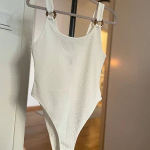 Vit body linne med detaljer vid axelbanden  - Vit body med fina detaljer vid axelbanden. Använd enstaka gång så är i väldigt fint skick!