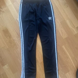 Adidasbyxor slits benslut - Adidasbyxor använda enstaka gång så är i väldigt fint skick. Storlek 36. Slits vid benen.
