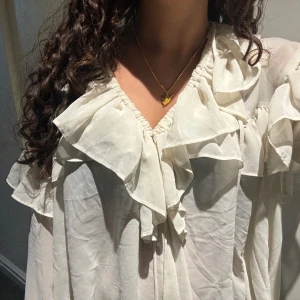 Volang Blus - Vit blus med volanger. Bra skick och inga synliga defekter förekommer. Hör av er för fler bilder. Kan sänka pris vid snabb affär.