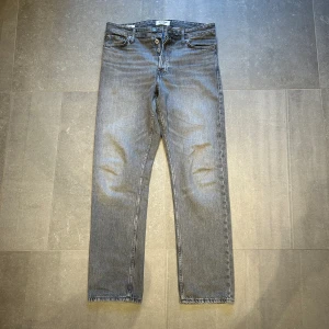 Gråa jeans - Säljer nu dessa jeans från Jack and Jones. Passformen är loose i storlek 30:32. De är i ett fräsht skick. Jag är 178cm och de sitter perfekt! De matchar till de mesta. Vid frågor eller funderingar är det bara att höra av dig! 