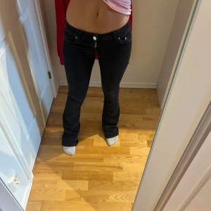 svarta lågmidjade jeans - Svarta lågmidjade bootcut jeans, köpta på Nelly. Superstretchiga och sköna! Slitningar längst ner dock eftersom de vart för långa på mig. 