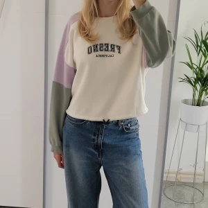 Pastell sweatshirt - Säljer denna söta tröjan från H&M. Går i krämvitt, ljuslila och grönt men snyggt tryck framtill. Har snöre insytt nertill så sweatshirten kan bli croppad om man vill! (Går även att dra ur helt).  Hör av dig om du har frågor!
