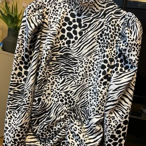 Klänning Ginatricot  - Fin halvpolo klänning från Ginatricot med svart och vit mönster. Puffaxlaf och scrunch både bak och fram. Aldrig använd. Storlek 36.