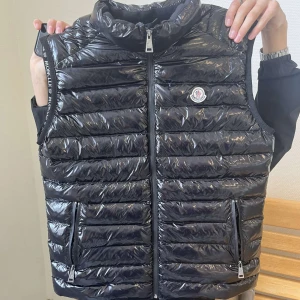 Moncler väst - Mycker fin moncler väst. Köpte den av någon annan så vet dessvärre inte ifall den är äkta men den ät i mycker bra kvalitet. Änvänd bara ett fåtal gånger så inga tecken på vårsslöst bruk.