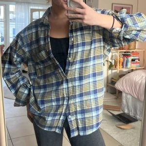 Rutig oversized flanell-skjorta - Oversized rutig skjorta i flanell köpt secondhand! Stl L, från ”Rifle Jeans and Jackets”. Mycket fint skick! Nyanser av blått, turkos, gult. 