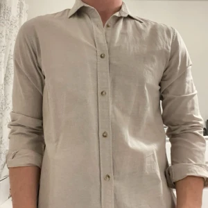 Beige skjorta - Skön skjorta som passar till sommaren. Knappt använd och sitter bekvämt på mig.