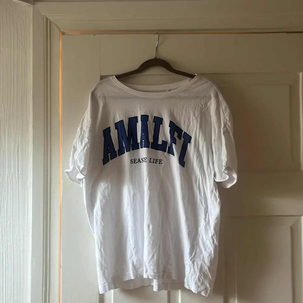 Oversized vit t-shirt med texten ”Amalfi, seaside life”. T-shirts.