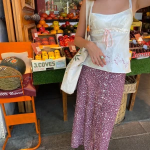 Blomster midikjol  - Super gullig sommar kjol, det är en midi kjol som kommer ner till anklarna. Lite burgundy i färg med vita små blommor och knappar längst fram. Har används några gånger men ändå i bra skick. 