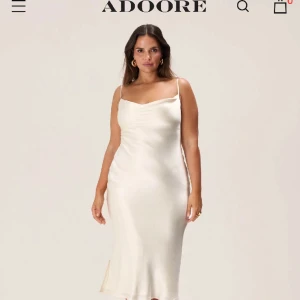 Vit klänning - Vit klänning/studentklänning från Adoore. Aldrig använd. Inköpt för 1395kr. Storlek 44 men den är liten i storlek som en 40/42.