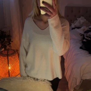 Vit stickad tröja - Vit stickad tröja med v ringning från Only, ett litet hål i höger ärmen längst ut och lite nopprig 