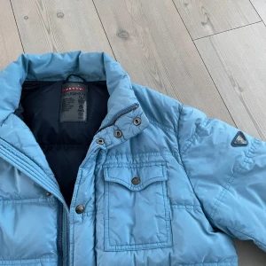 Prada jacka  - Galet snygg vintage prada jacka i bra skick inga skador alls! Sjukt eftertraktad jacka och en sällsynt färg, size 52 passar M/L, nypris uppåt 15000kr, kom med ett bud Äktahetsbevis finns! 