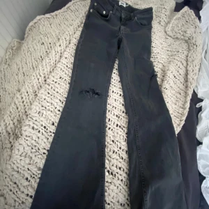Jeans med hål - Jag säljer ett low waist bootcut jeans. Sälgs pågrund av att det var för korta. 