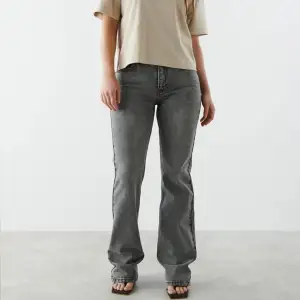 Jeans med medelhög midja, från Gina tricot. Jeansen är gråa och har en slim fit i denim med stretch. De har utsvängda ben med fullängd och dragkedjegylf. Passar för dig som är 167+